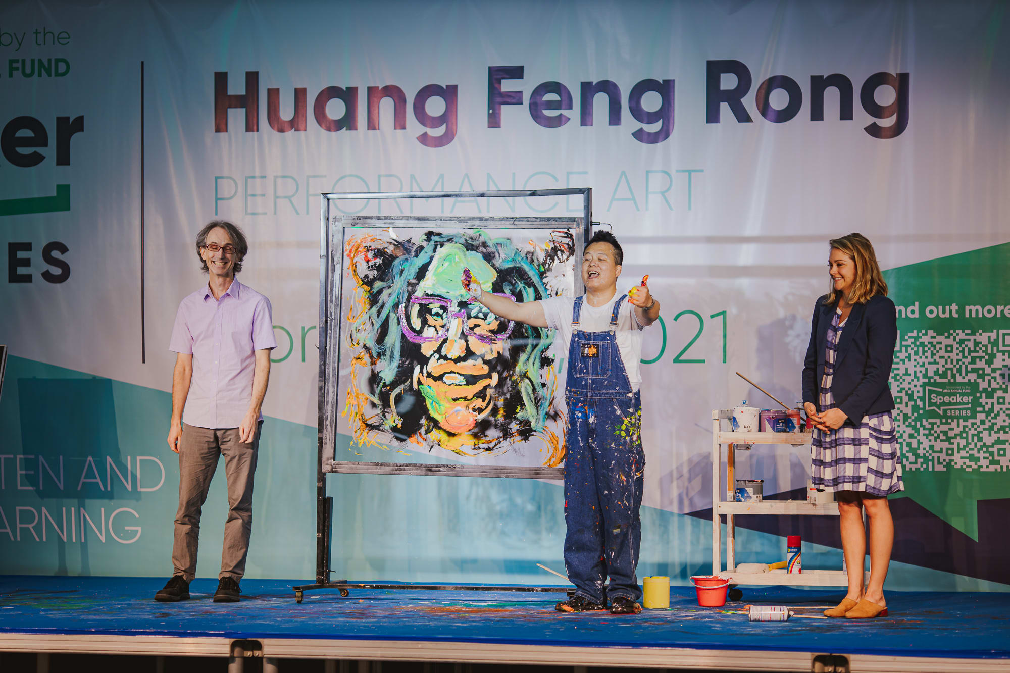 artist showing off portraits of two people