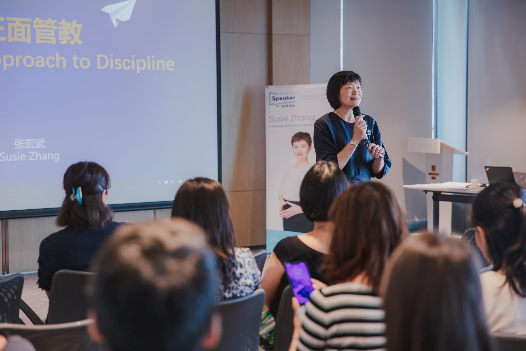 woman talking into microphone to people sitting