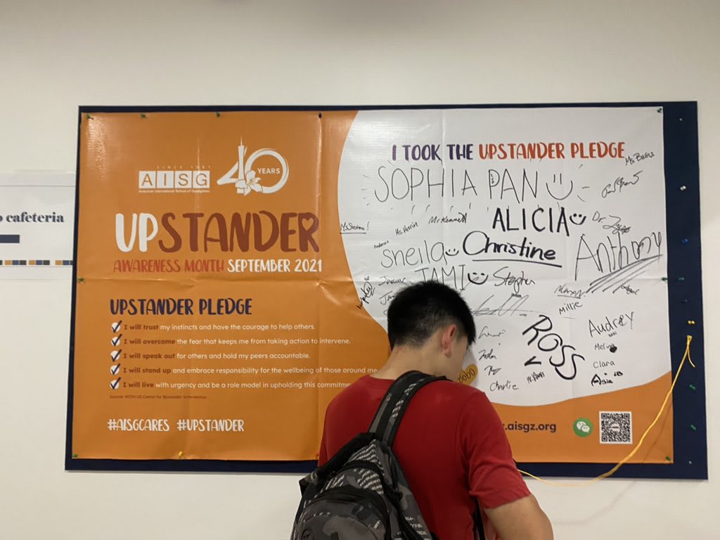 AISG Secondary School student signing in a full Upstander pledge sign