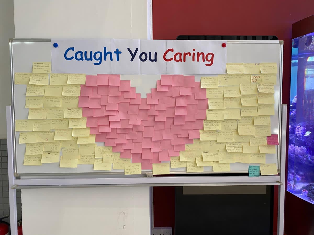 white board with a bunch of sticky notes in the shape of a heart