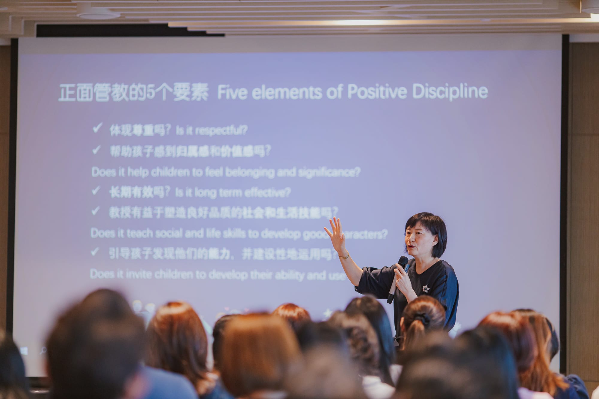 women giving presentation talking into microphone