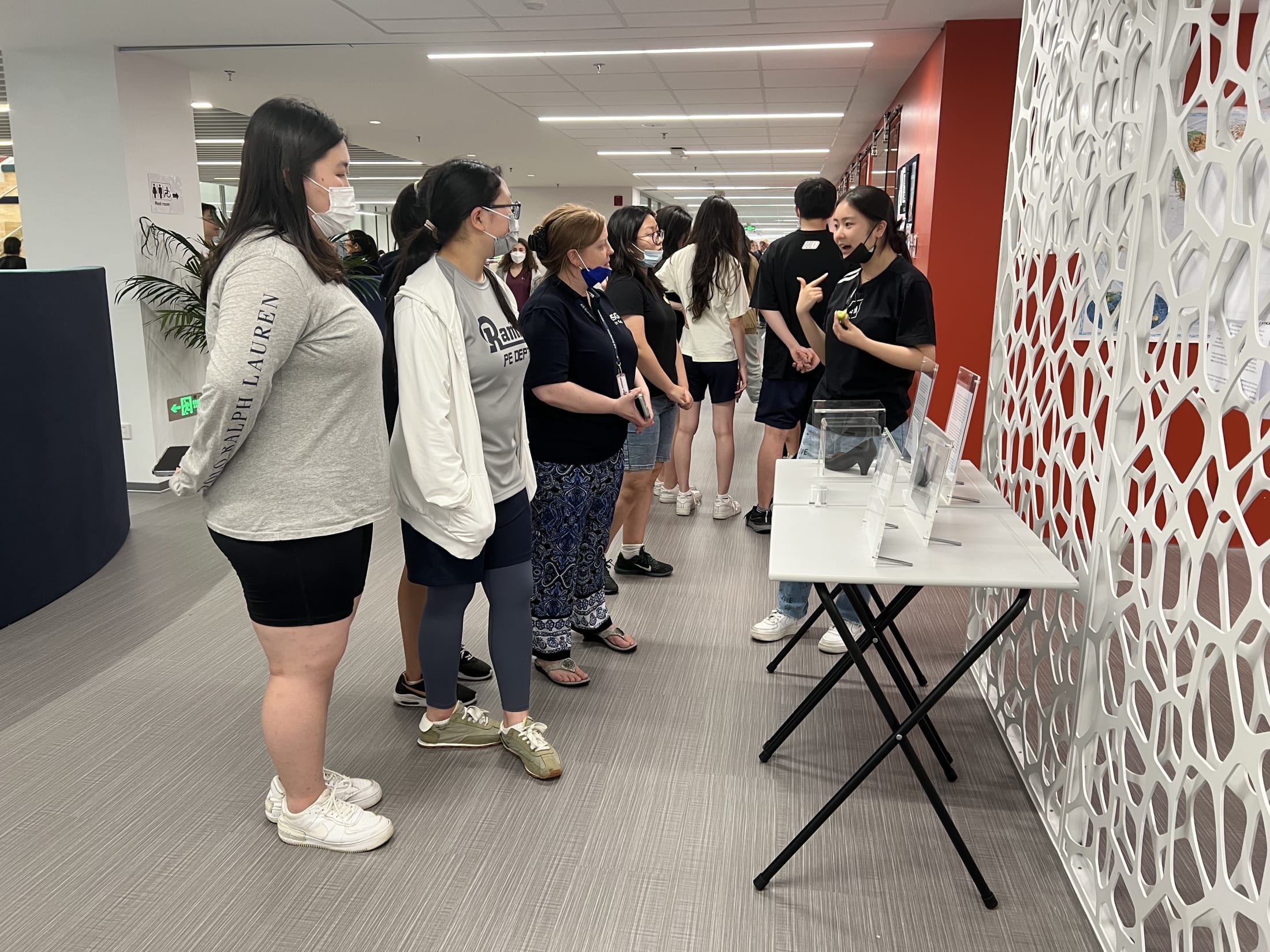 AISG TOK Exhibition with a student presenting her research to others