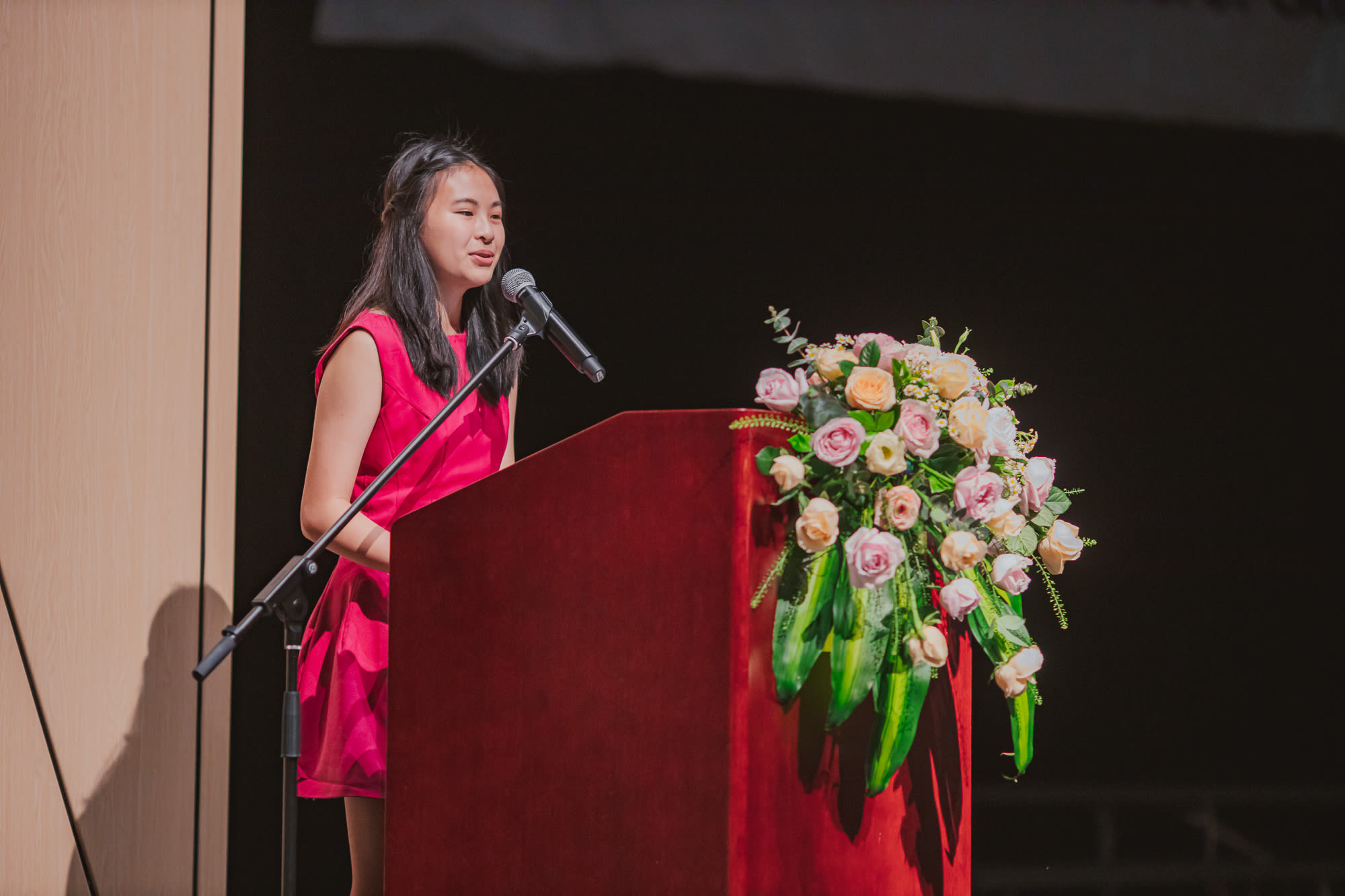 AISG Grade 8 Promotion female student giving speech onstage