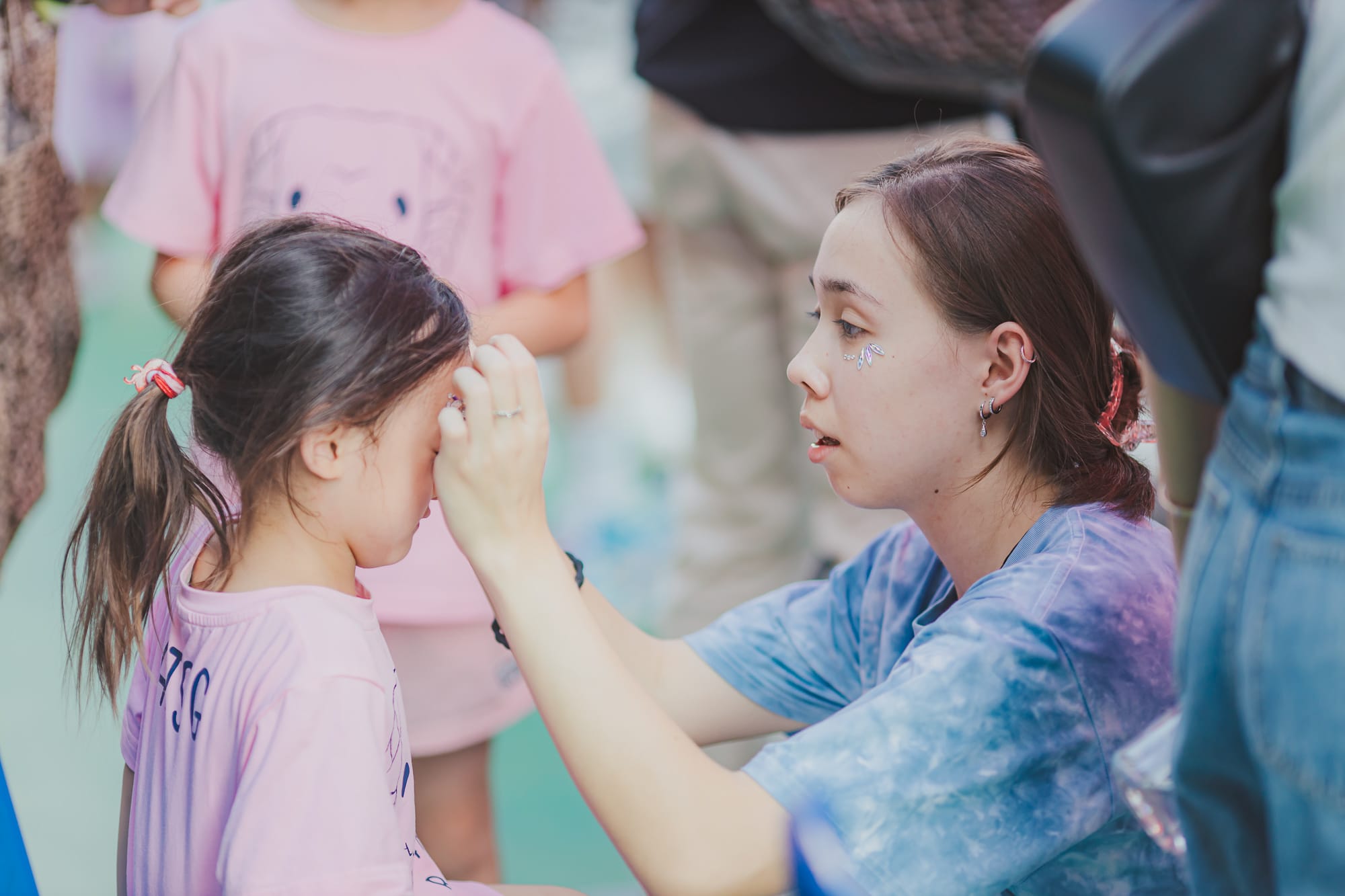 aisg family fun day student decorating face with stickers
