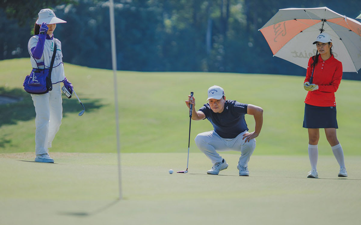 a golfer is scrutinizing a putt