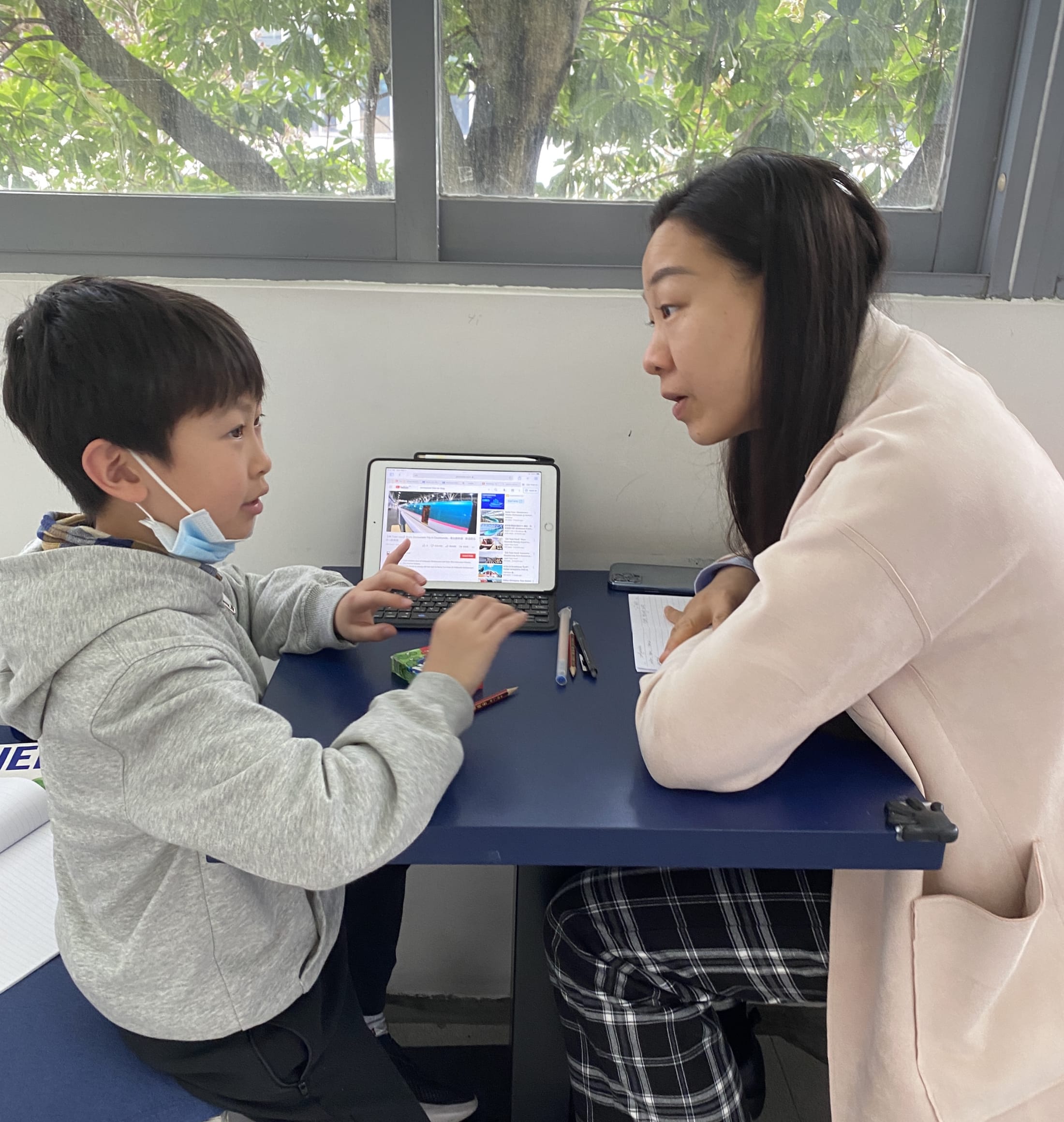 AISG PYPx with a student talking with a parent volunteer about his project