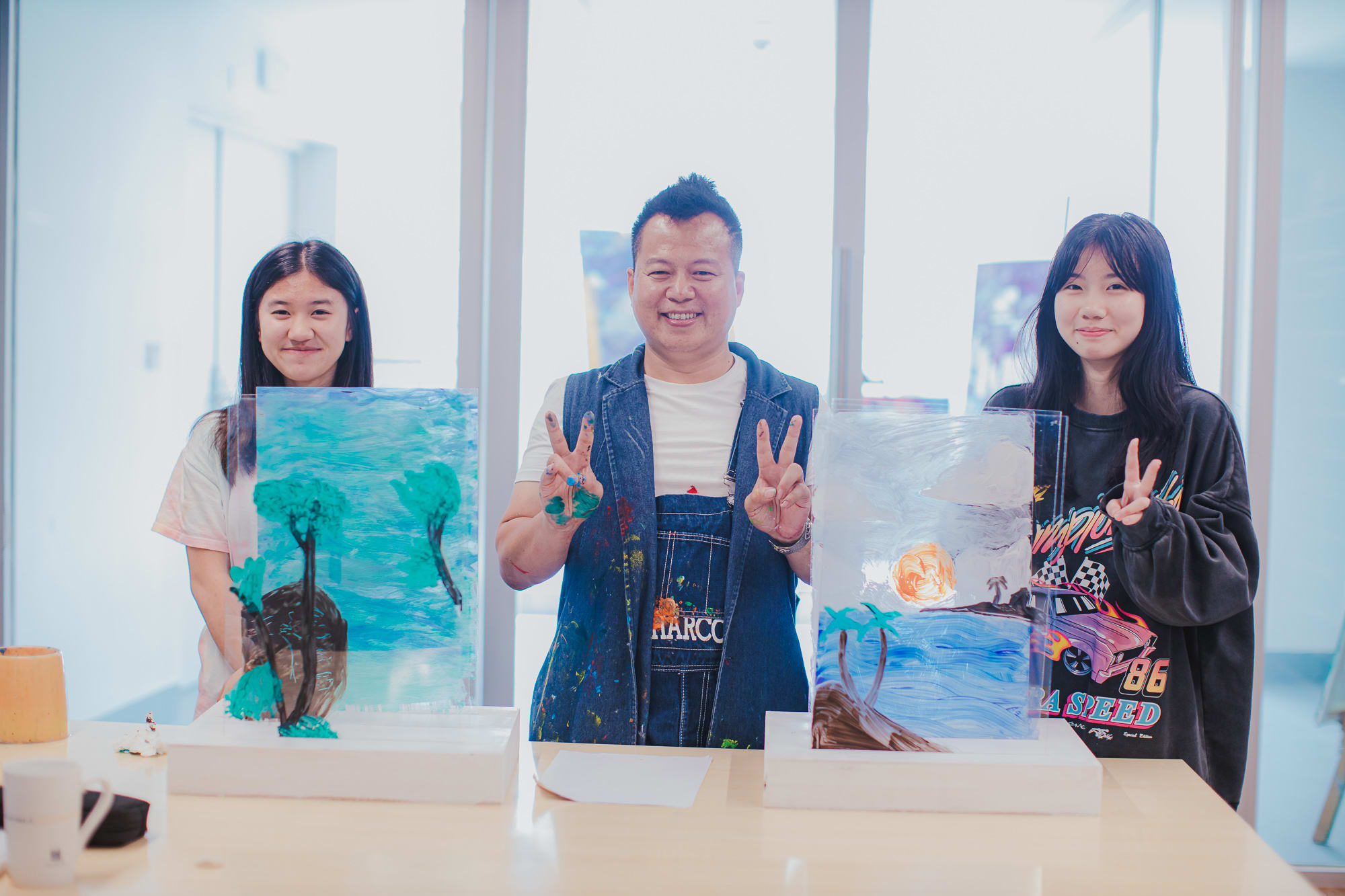 students and artist posing with their work