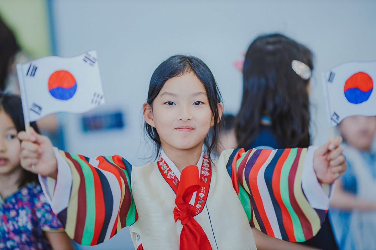 student holding up the flag of south korea