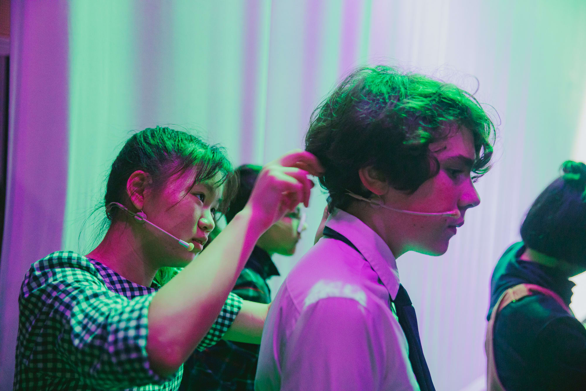 photo of one student helping the other with their microphone