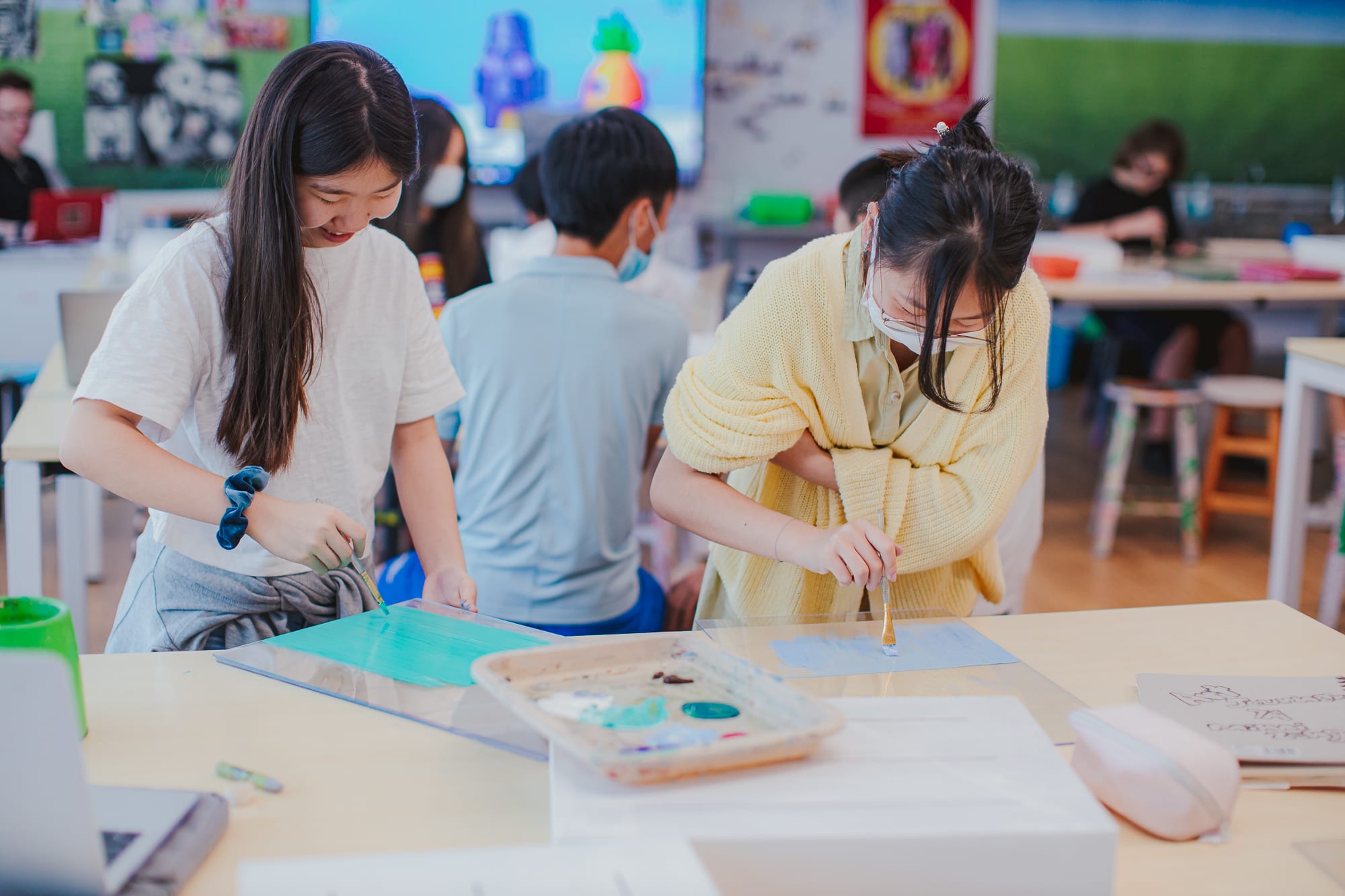 students painting on clear panels