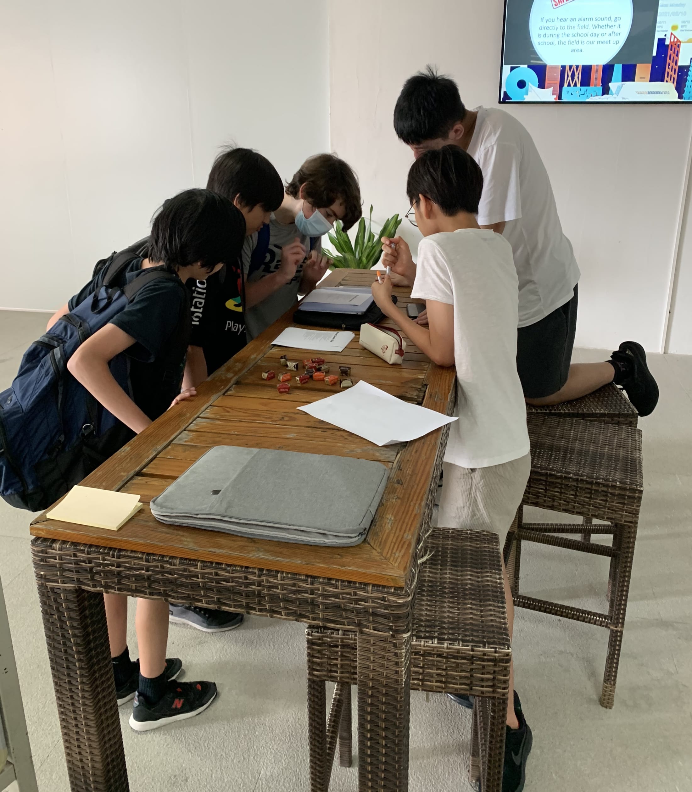boys crowded around looking at a paper