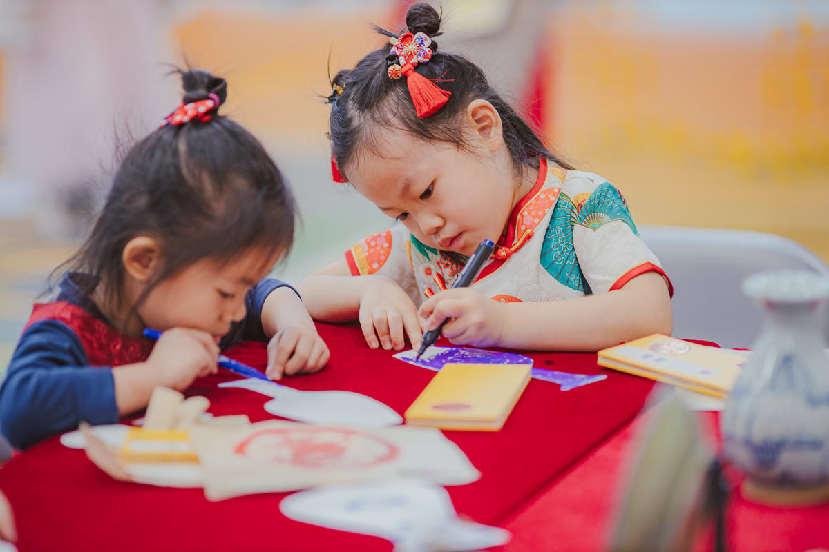 two girls doing an activity during the CNY culture celebration