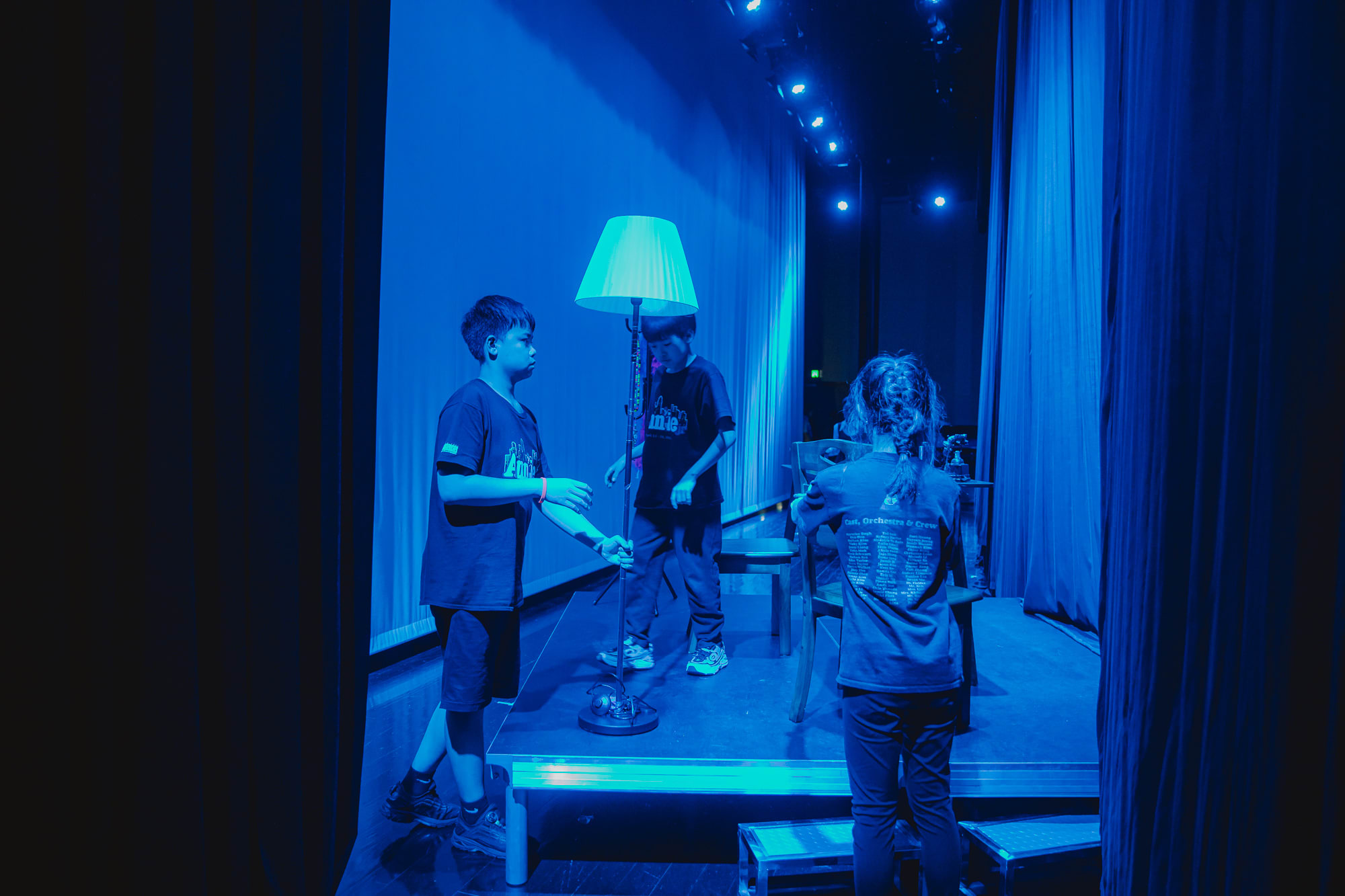 students backstage acting as stagehands helping with set pieces