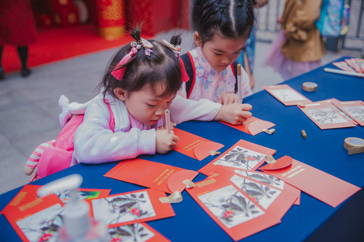 a student contributes her artwork for the giving envelopes