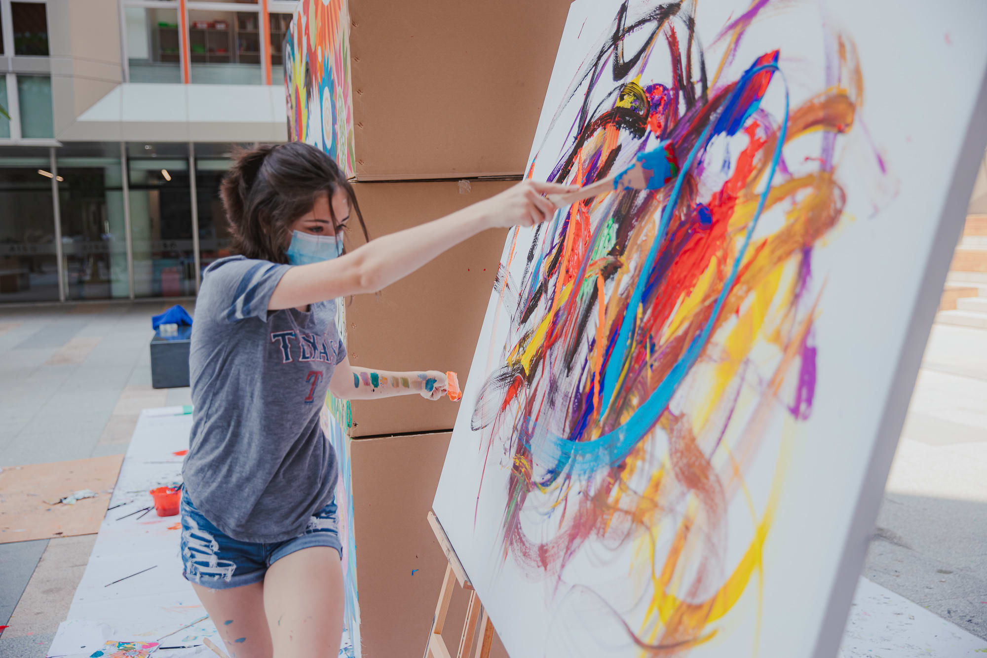 girl painting abstract colors on canvas