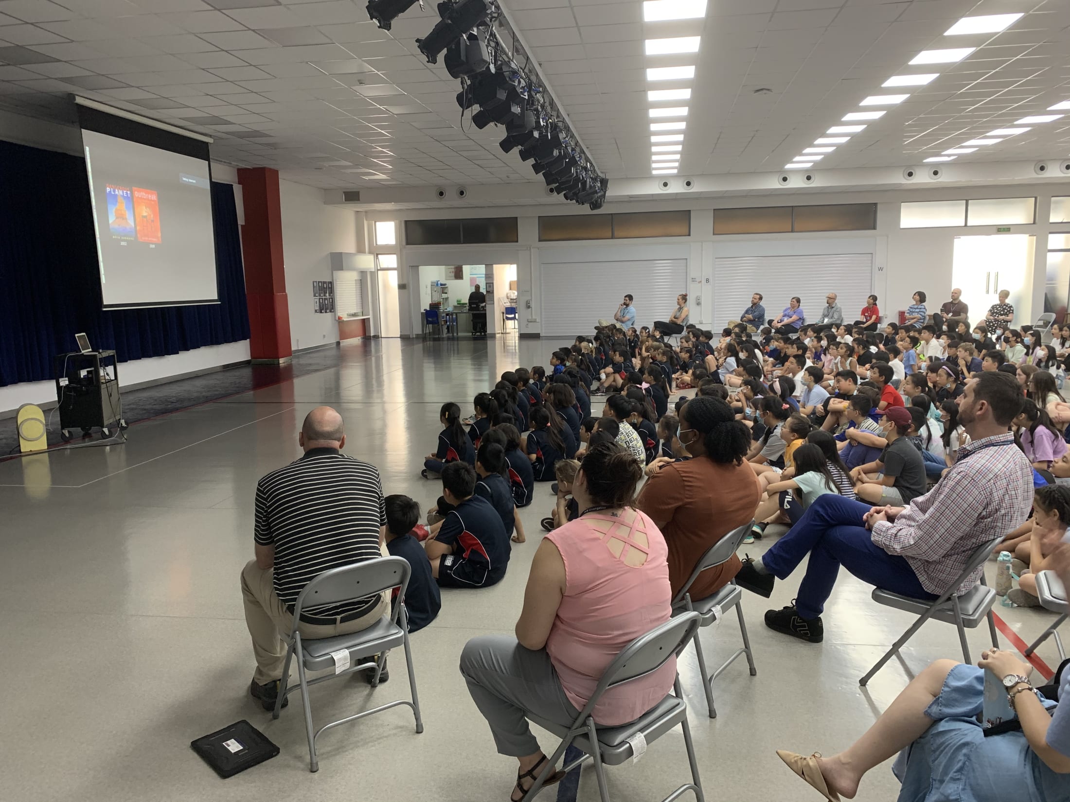 crowd of children watching presentation on screen