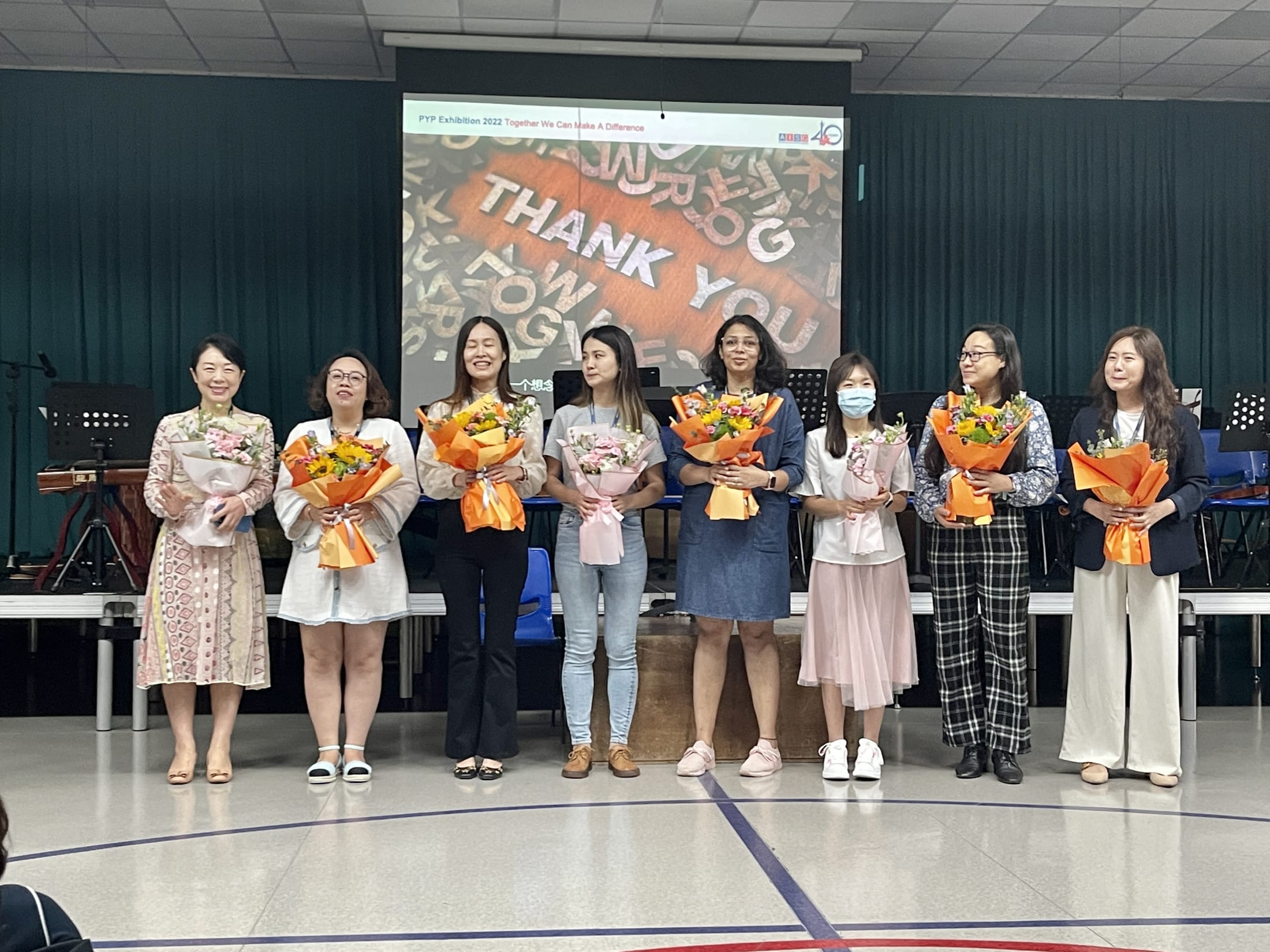 AISG PYP Exhibition with parent volunteers holding their bouquets of flowers