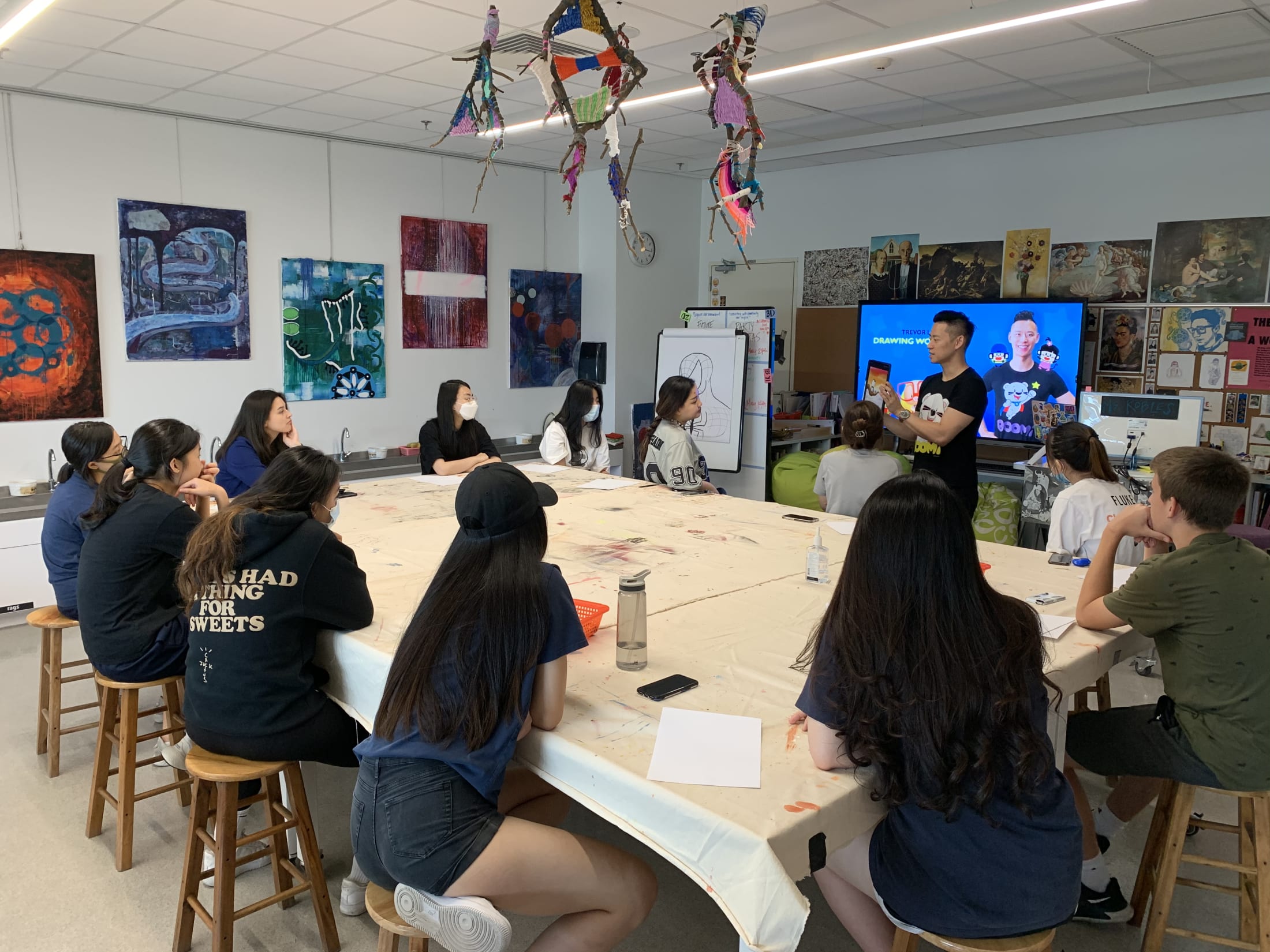 students sitting in art class watching man talk