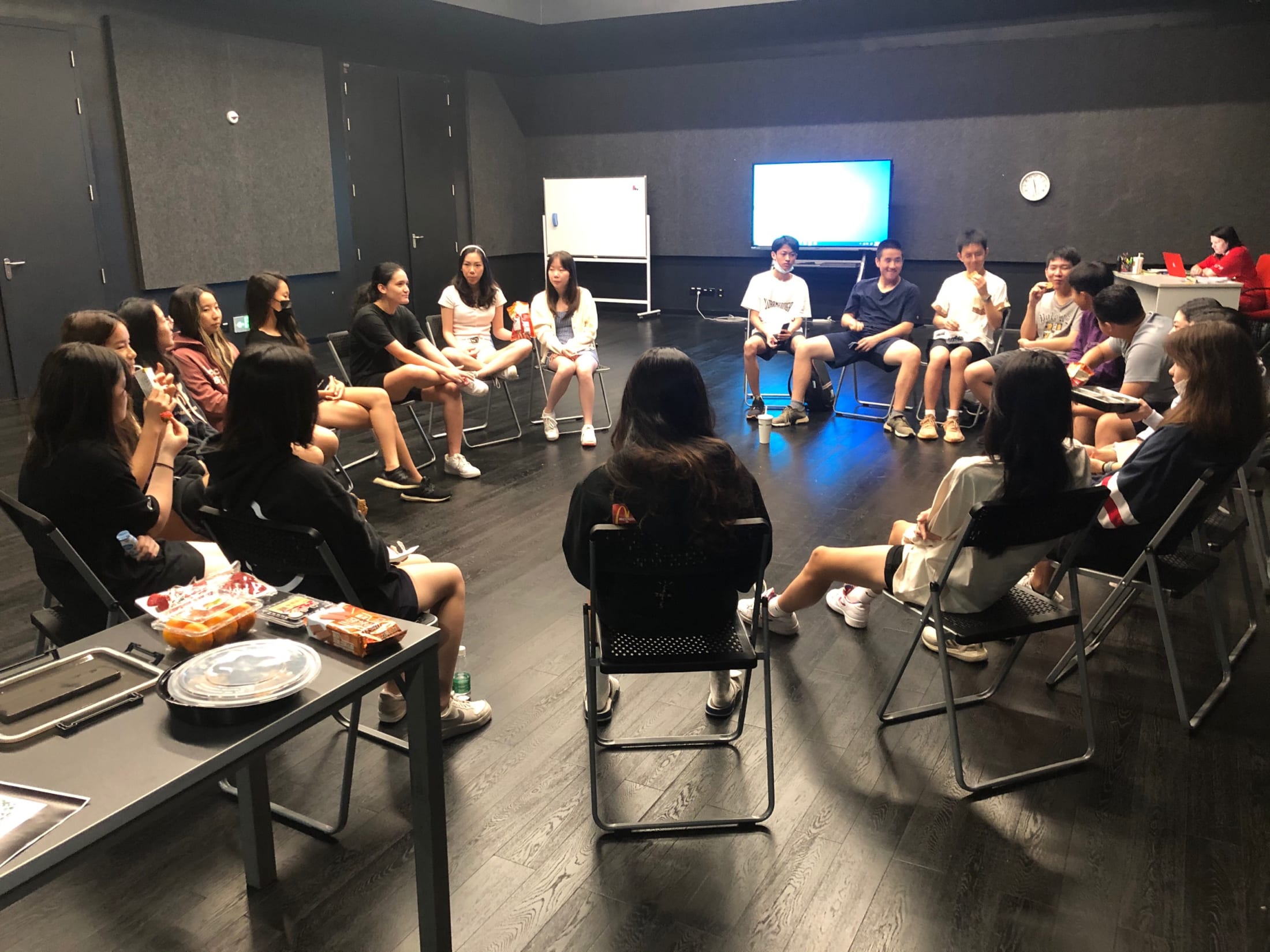 group of students sitting in a circle on chairs