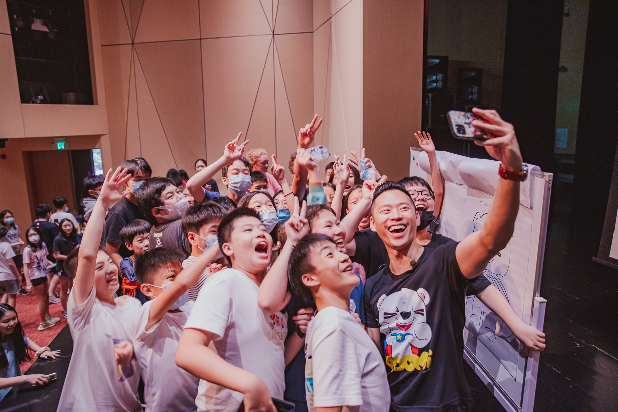 group of students excitedly taking selfie with man