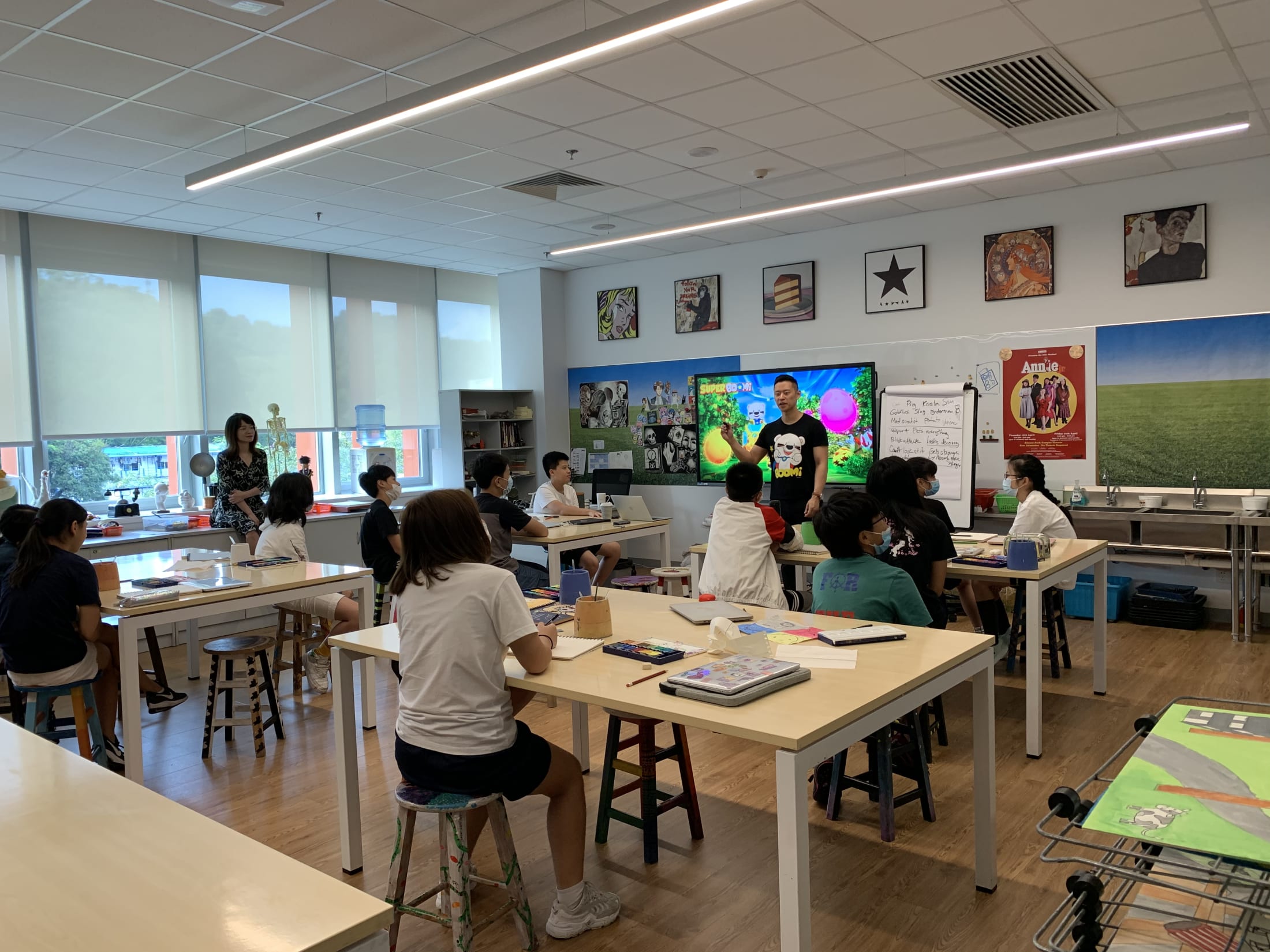 students sitting in art class listening to man speak