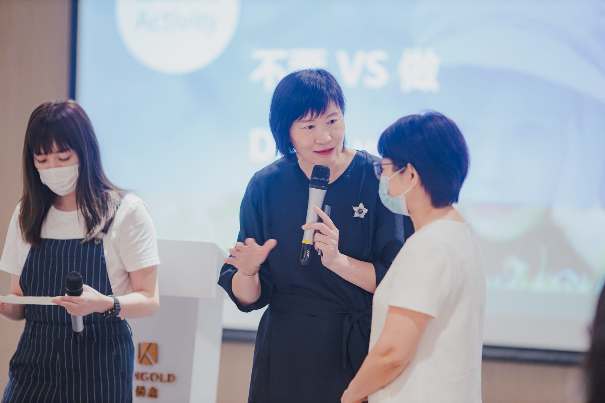 woman talking into microphone to someone next to her