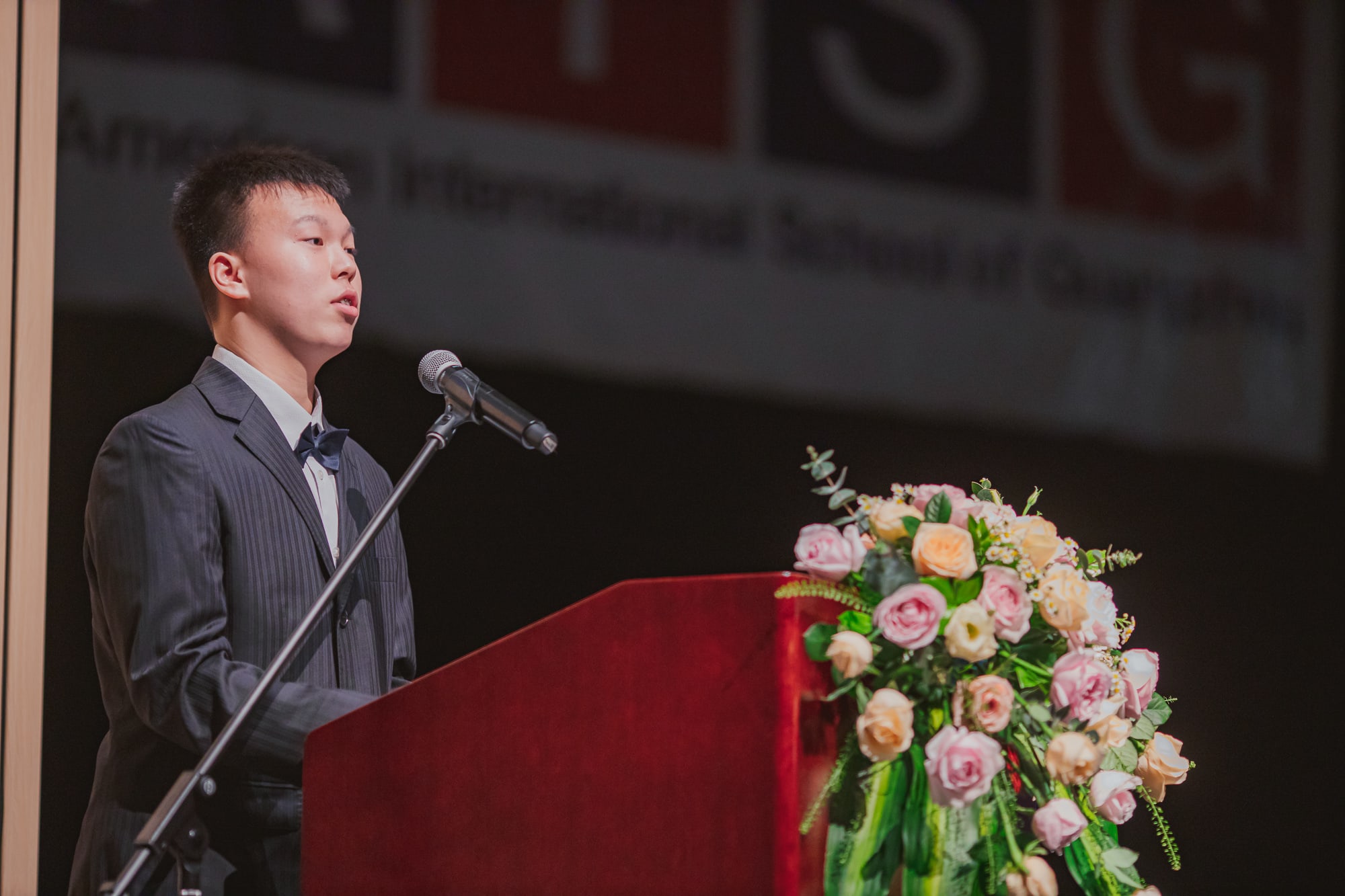 AISG Grade 8 Promotion male student making speech onstage