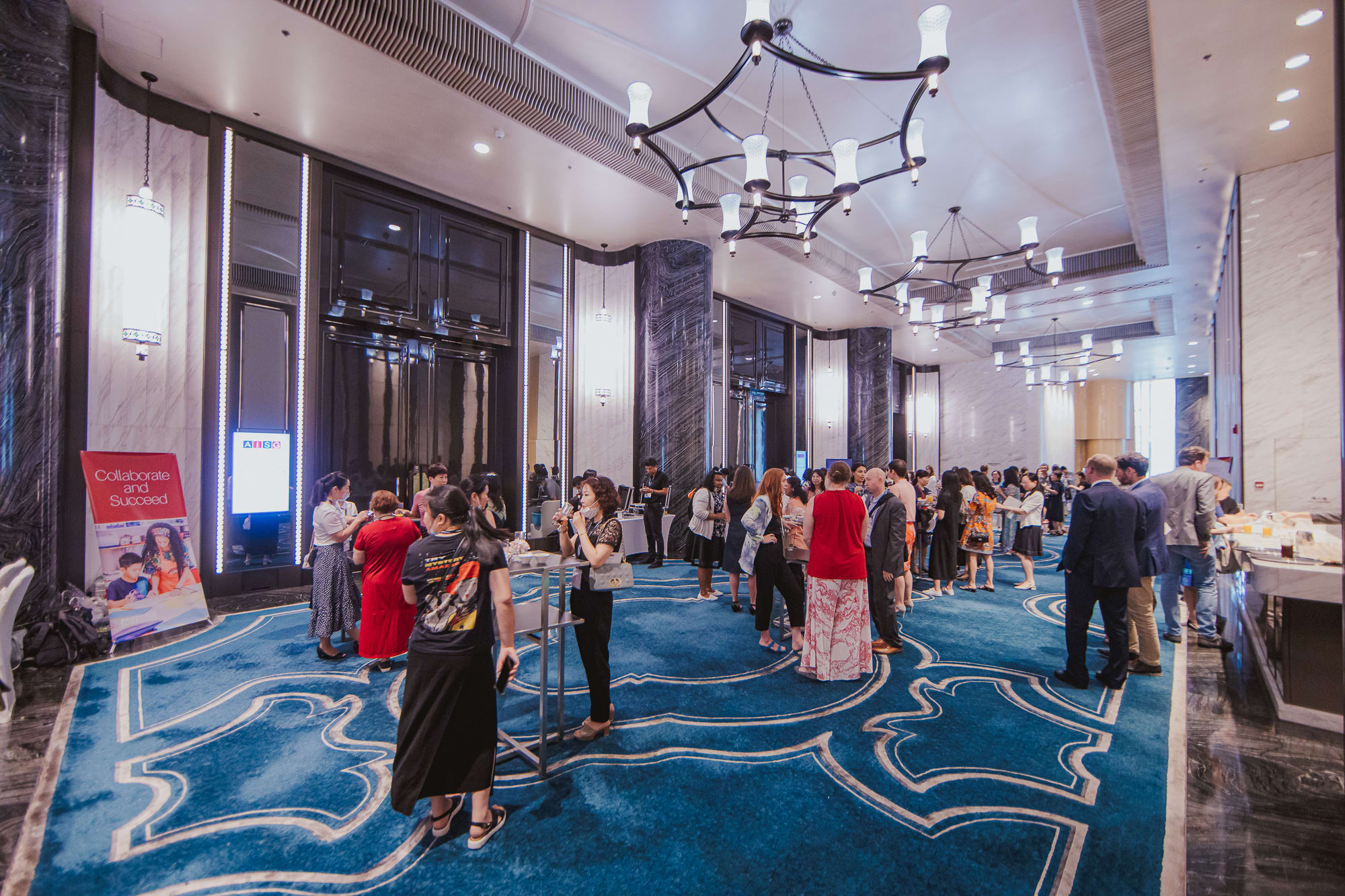 groups of people standing in a fancy hotel talking to each other