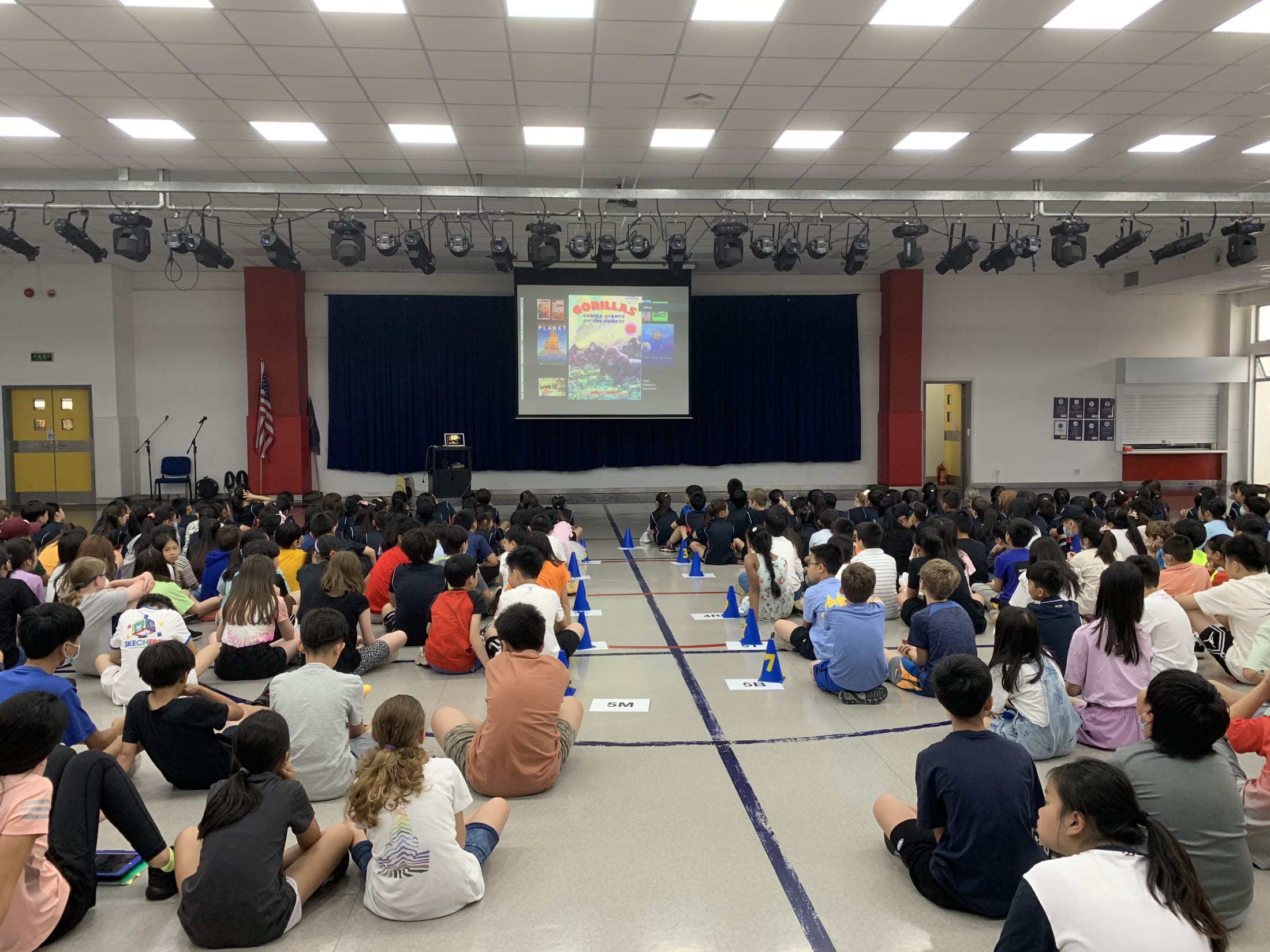 children sitting on floor watching presentation on screen