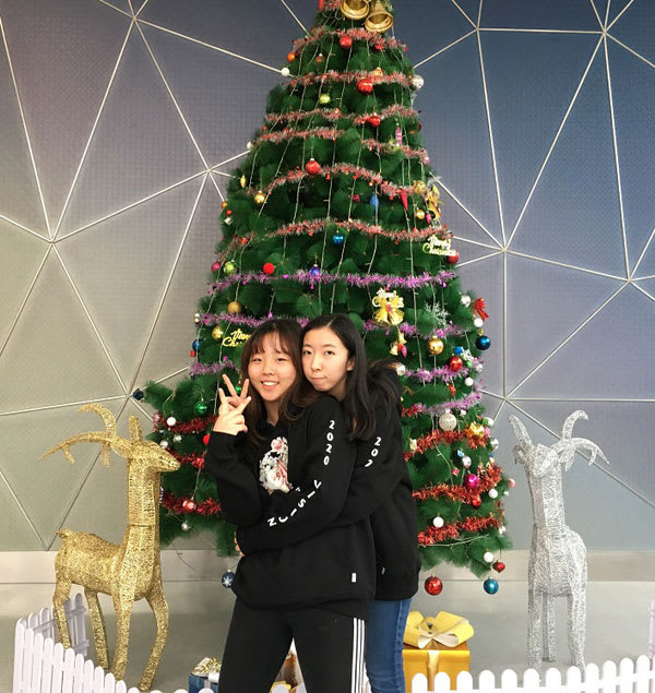picture of Miku Makino and a friend standing in front of a decorated Christmas tree