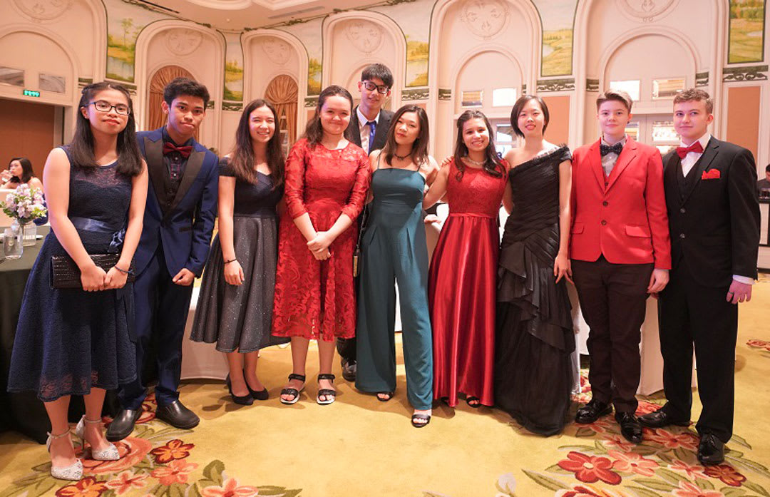 picture of some AISG students in gowns and suits