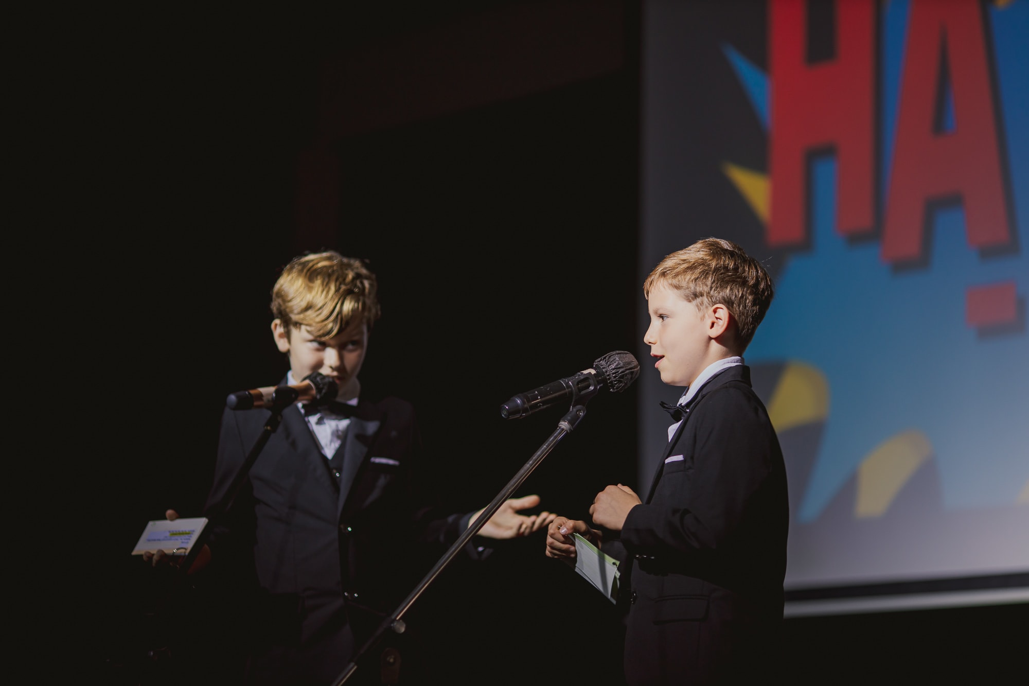 two boys talking into micrphones onstage