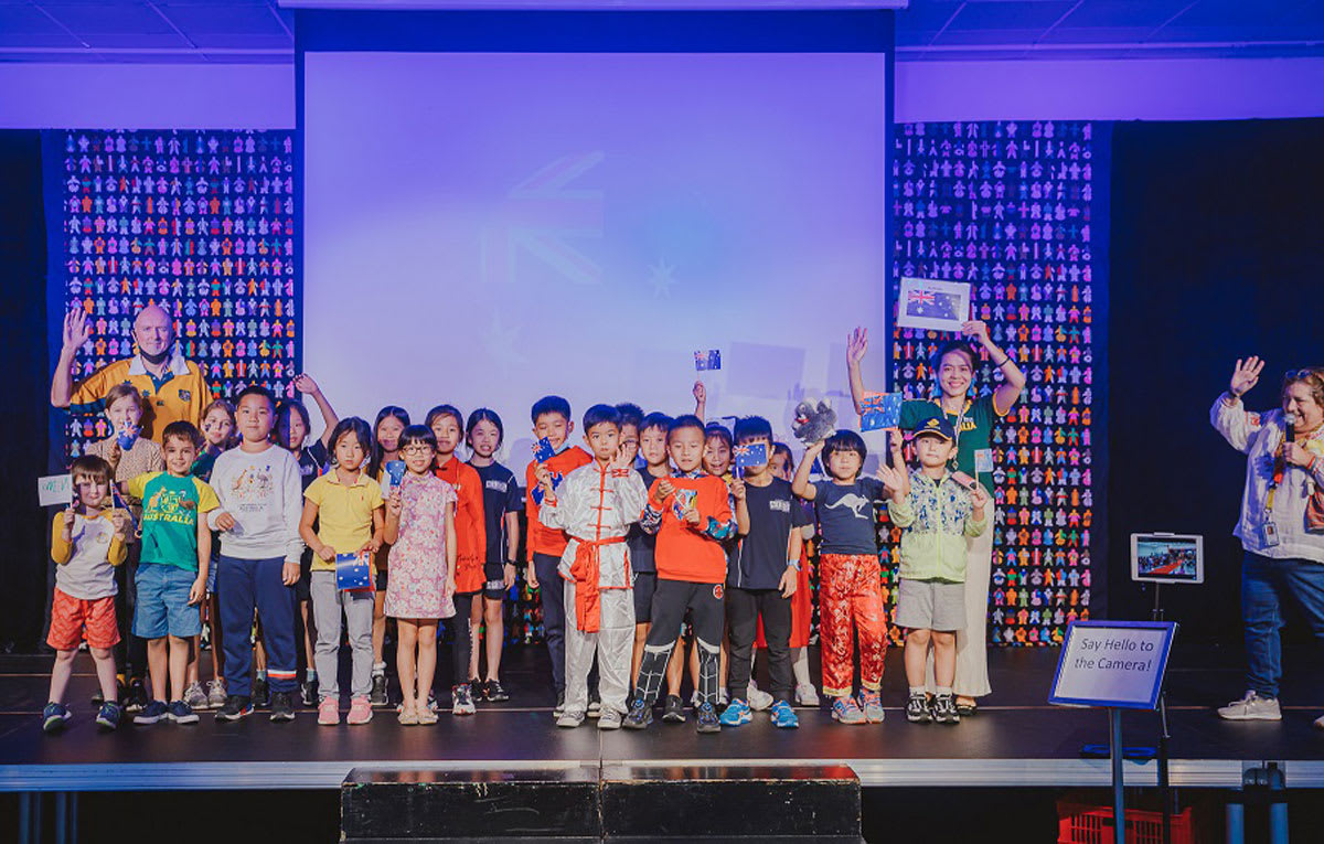students standing on a stage at UN day with the Australian National flag behind them
