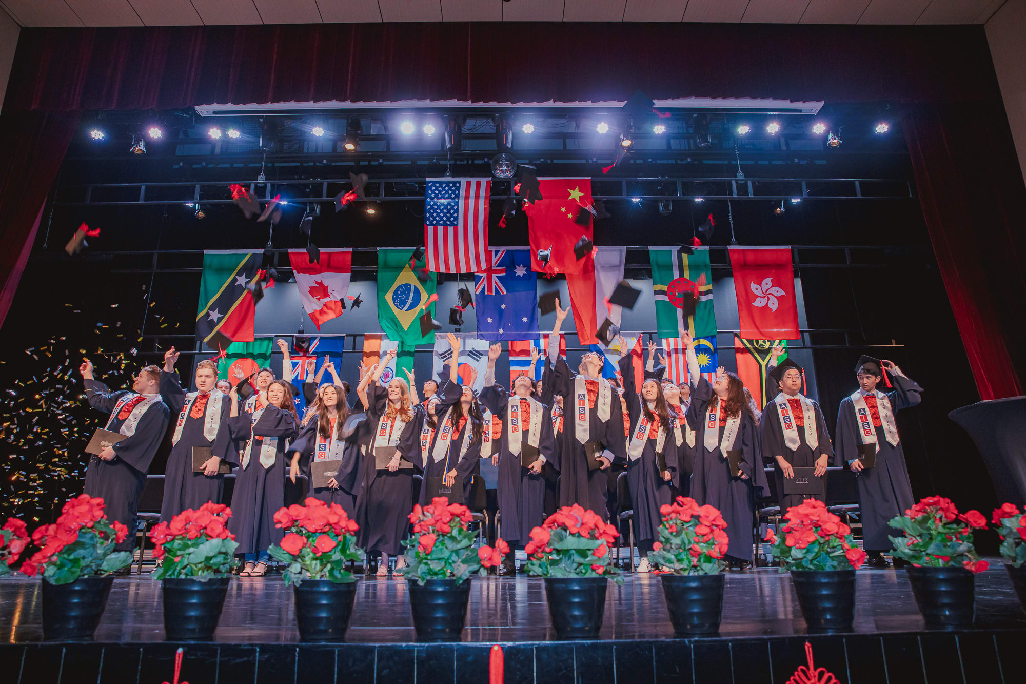 AISG Graduation with confetti as graduates throw their graduation caps in the air