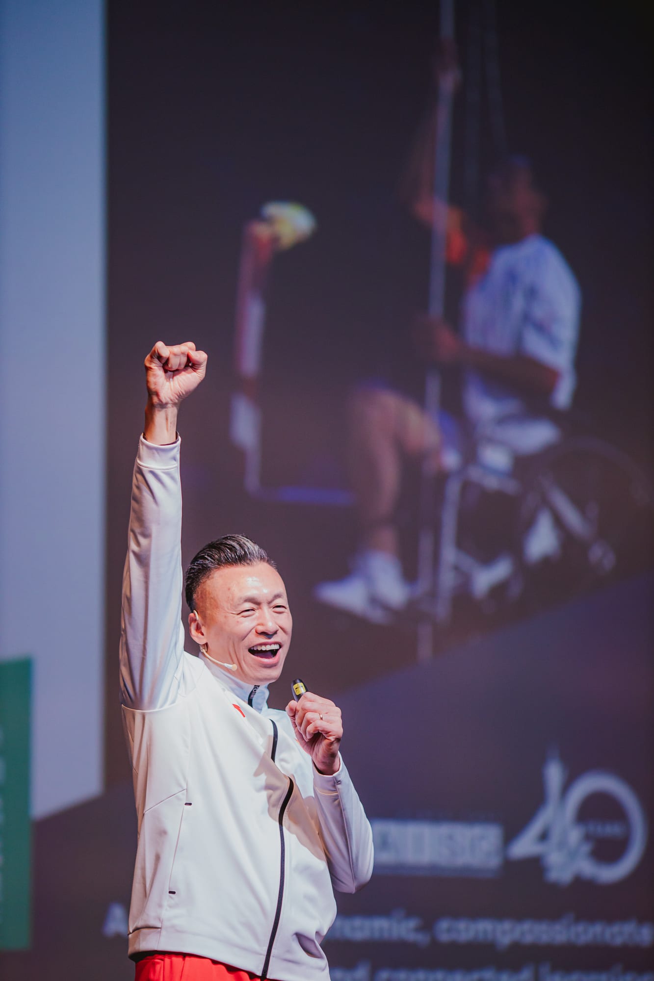 AISG Speaker Series with Hou Bin in Science Park stage with his fist up