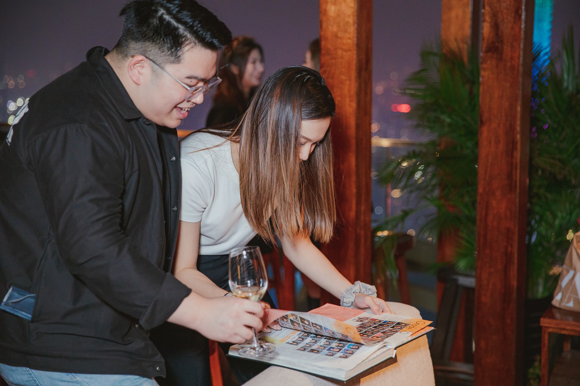 AISG alumni looking at old yearbooks, reminiscing on memories, at the alumni Ram Gathering event