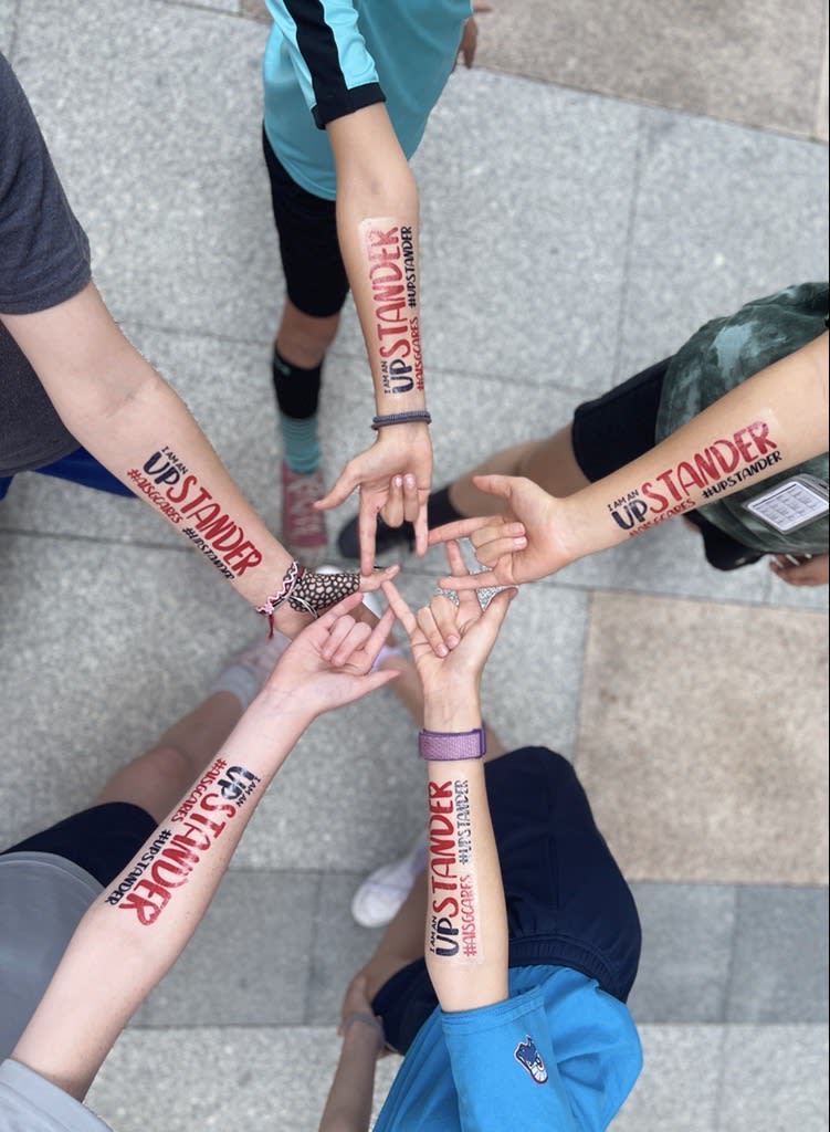 Five AISG Secondary School students showing their Upstander tattoos in a star shape