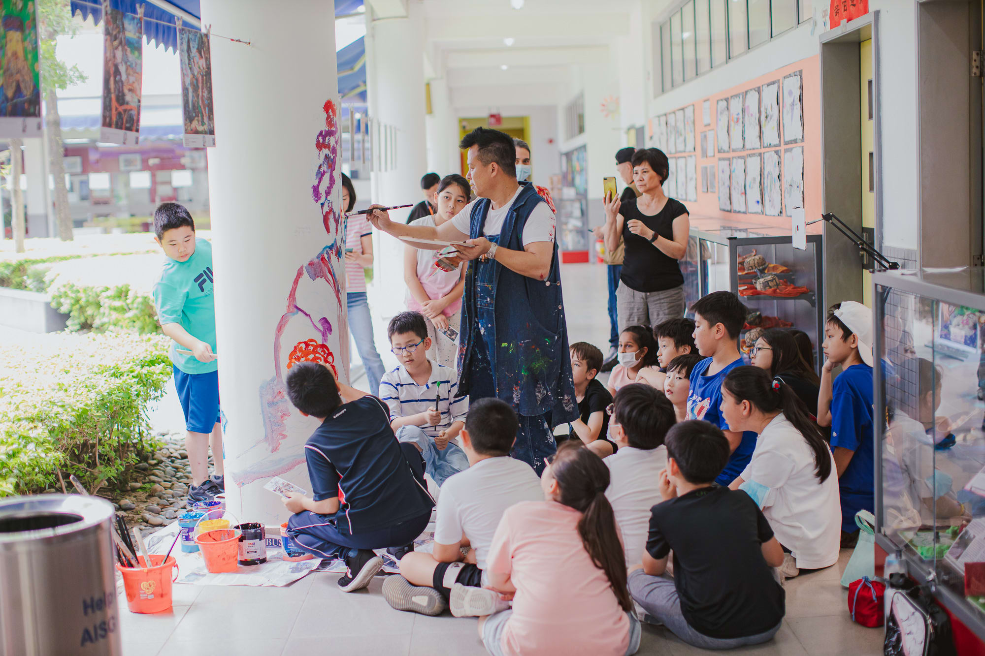 artist paints on pillar as students watch