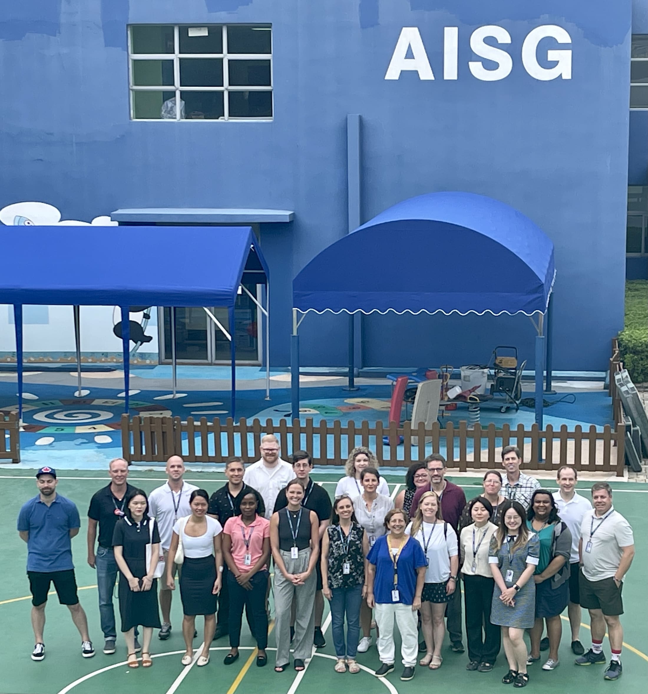 AISG's SY2122 new faculty group photo with Ersha blue building on the background
