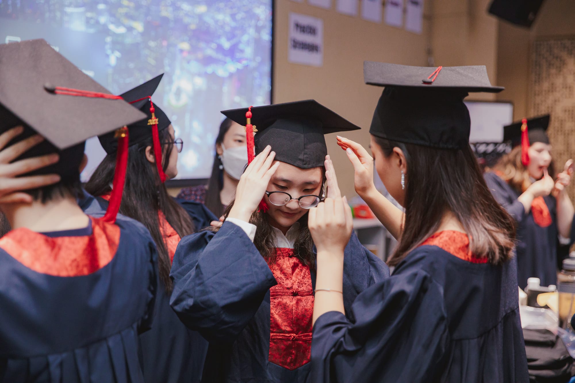 students helping fix each other's graduation caps