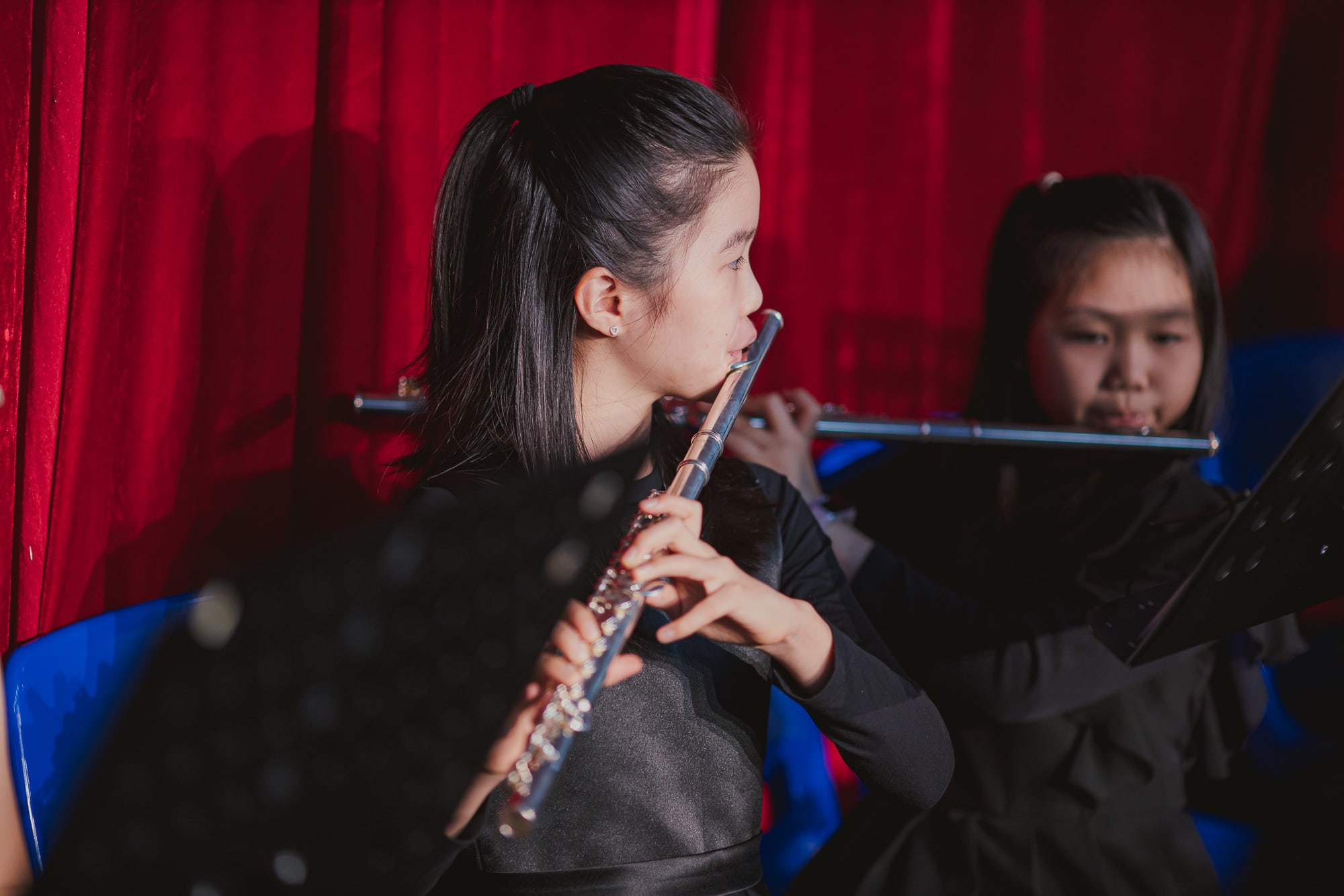 AISG elementary school student playing a flute in a performance