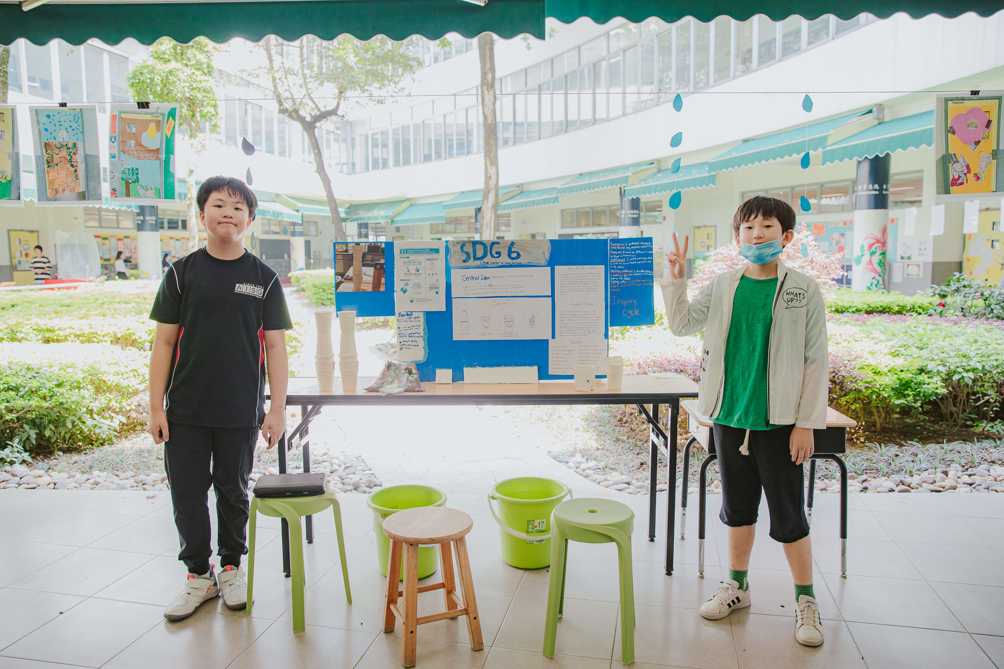 AISG PYP Exhibition with students standing by their presentation board