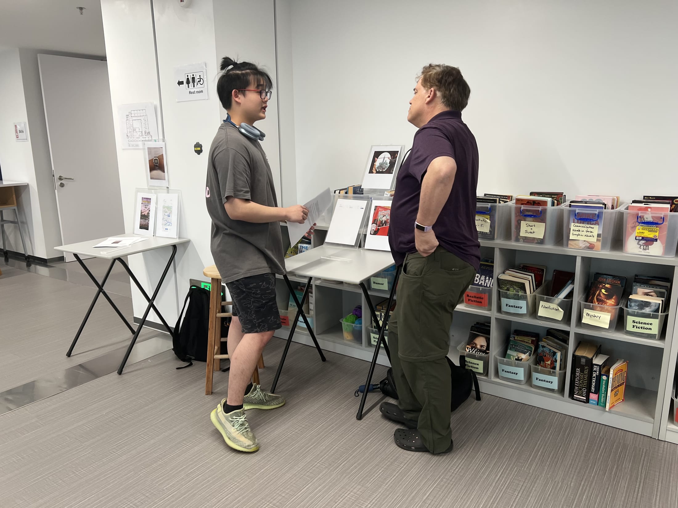 AISG TOK Exhibition with a student presenting his research to a teacher