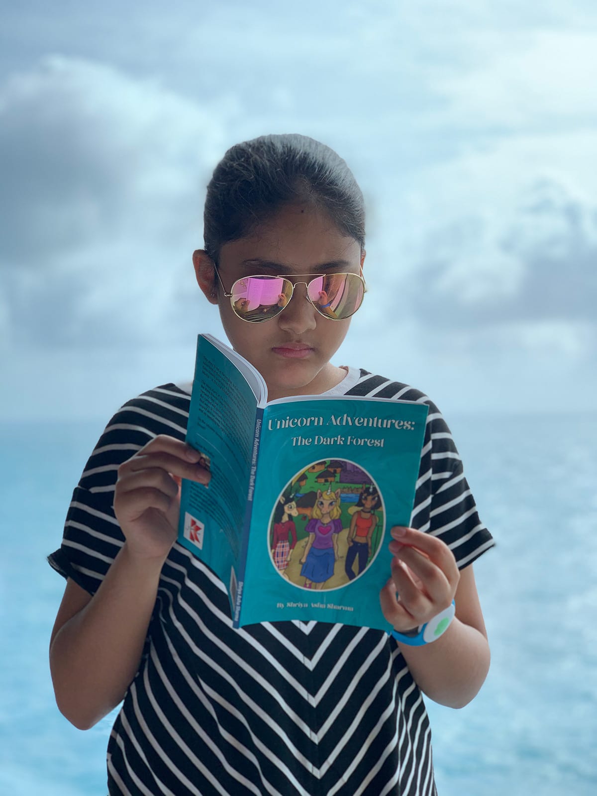 A girl is standing and reading her book