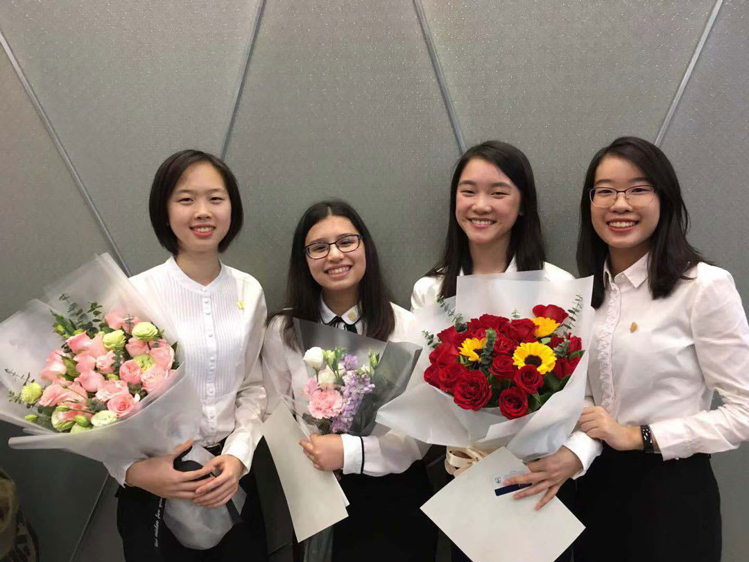 picture of four girls holding flowers after graduation