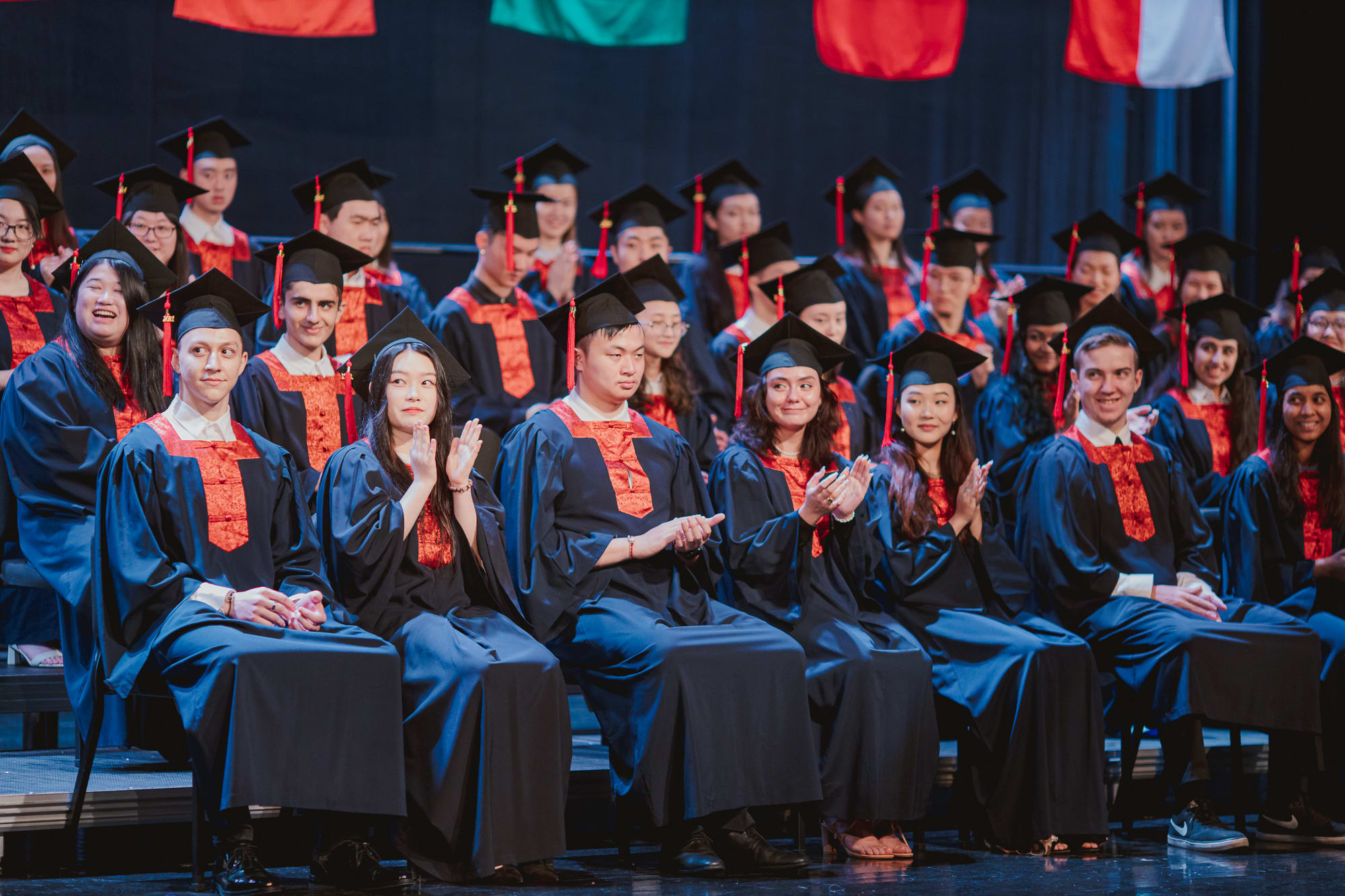 graduates seated laughing and clapping