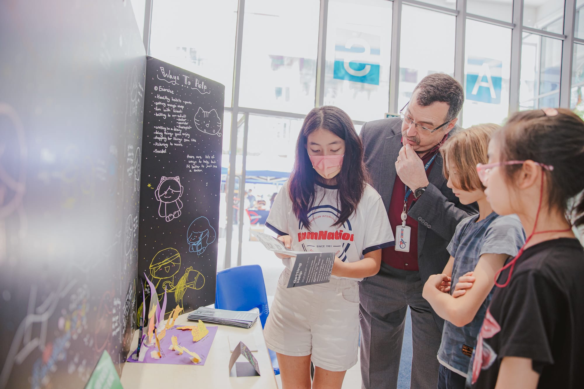 AISG PYP Exhibition with a student presenting to the director and other students about her project