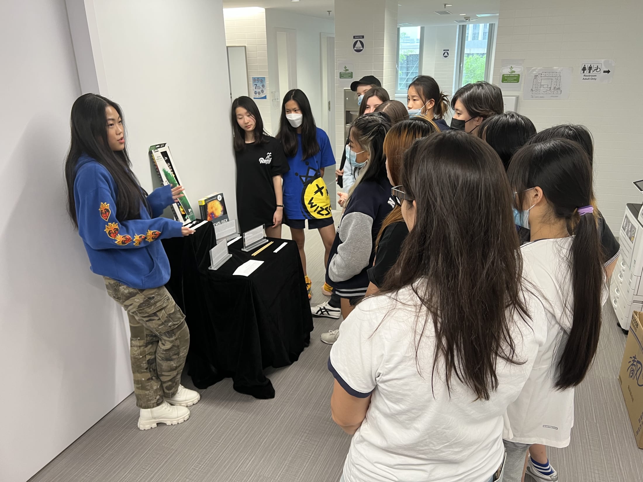 AISG TOK Exhibition with a student presenting her research to others