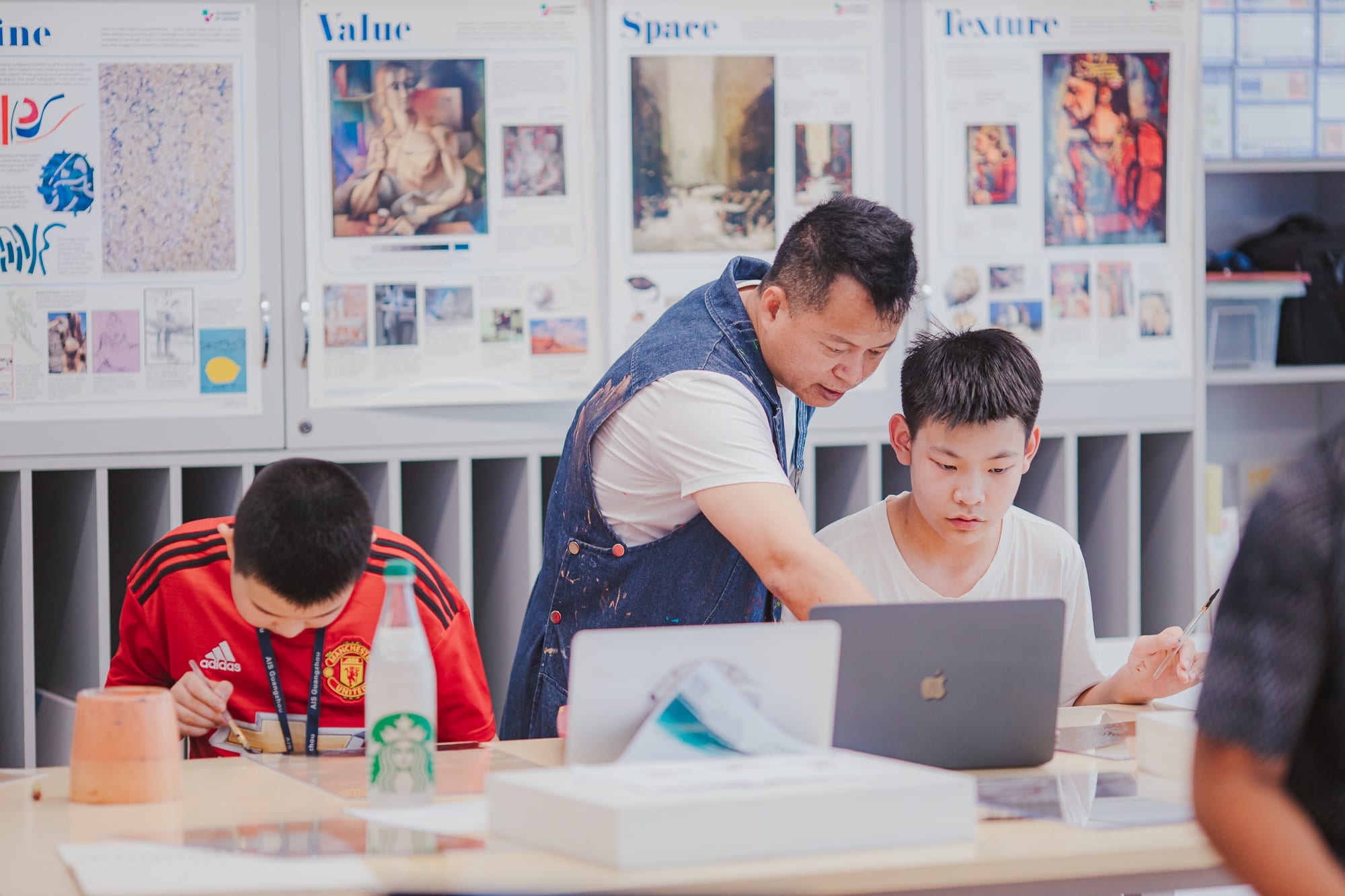artist helping student with his work