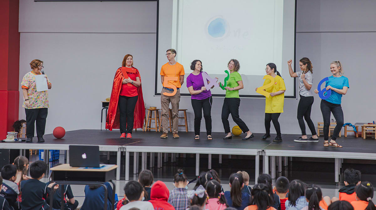 Primary school principle and teachers playing on the stage